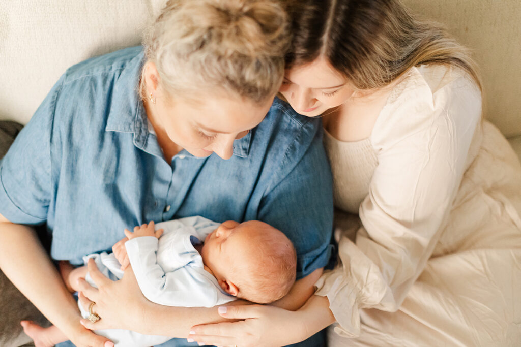 Mother holding newborn in candid family portrait.