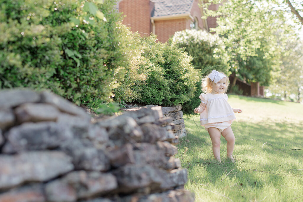 Toddler exploring the front yard during lifestyle family photo session in Little Rock.