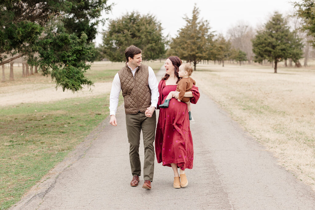 Family walking together in coordinated fall outfits with earthy tones and textures during a photo session in Central Arkansas