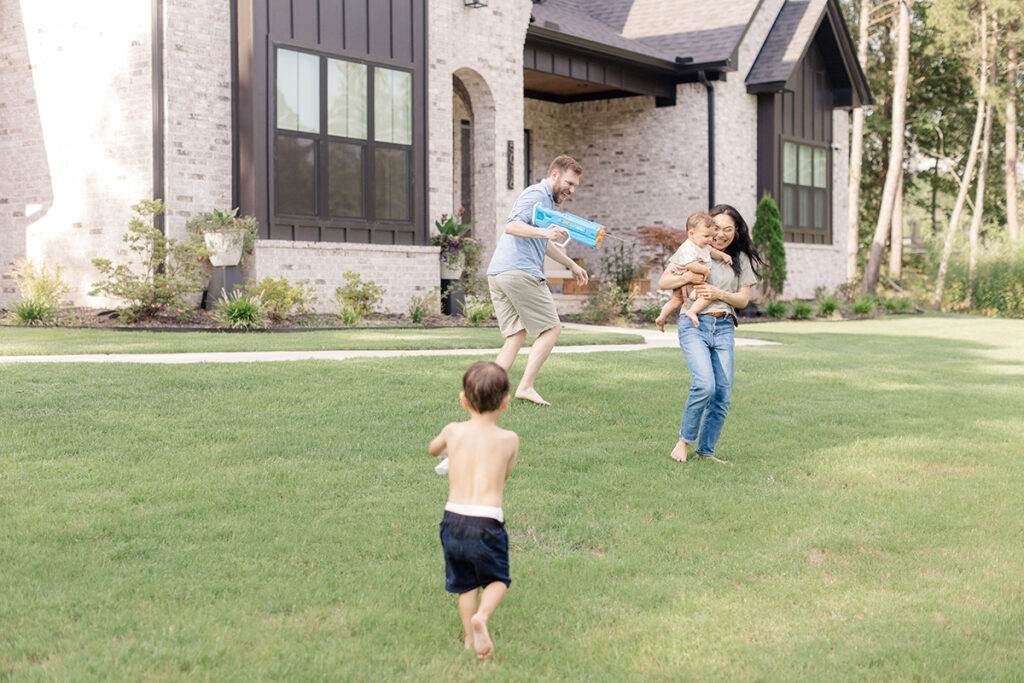 Outdoor Water Gun Fight with Little Rock Arkansas Family during their playful family photoshoot