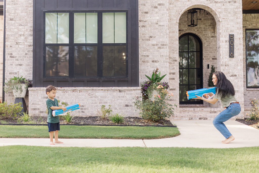 mother and son in middle of water gun fight