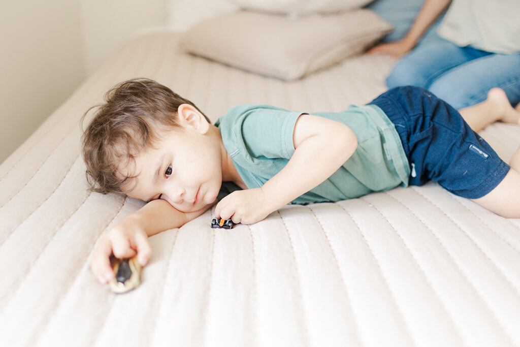 toddler driving and playing with toy cars during a playful family photography session