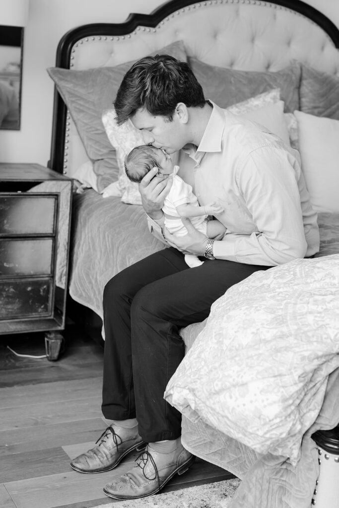 black and white portrait of father holding newborn during a candid lifestyle family portraits in little rock